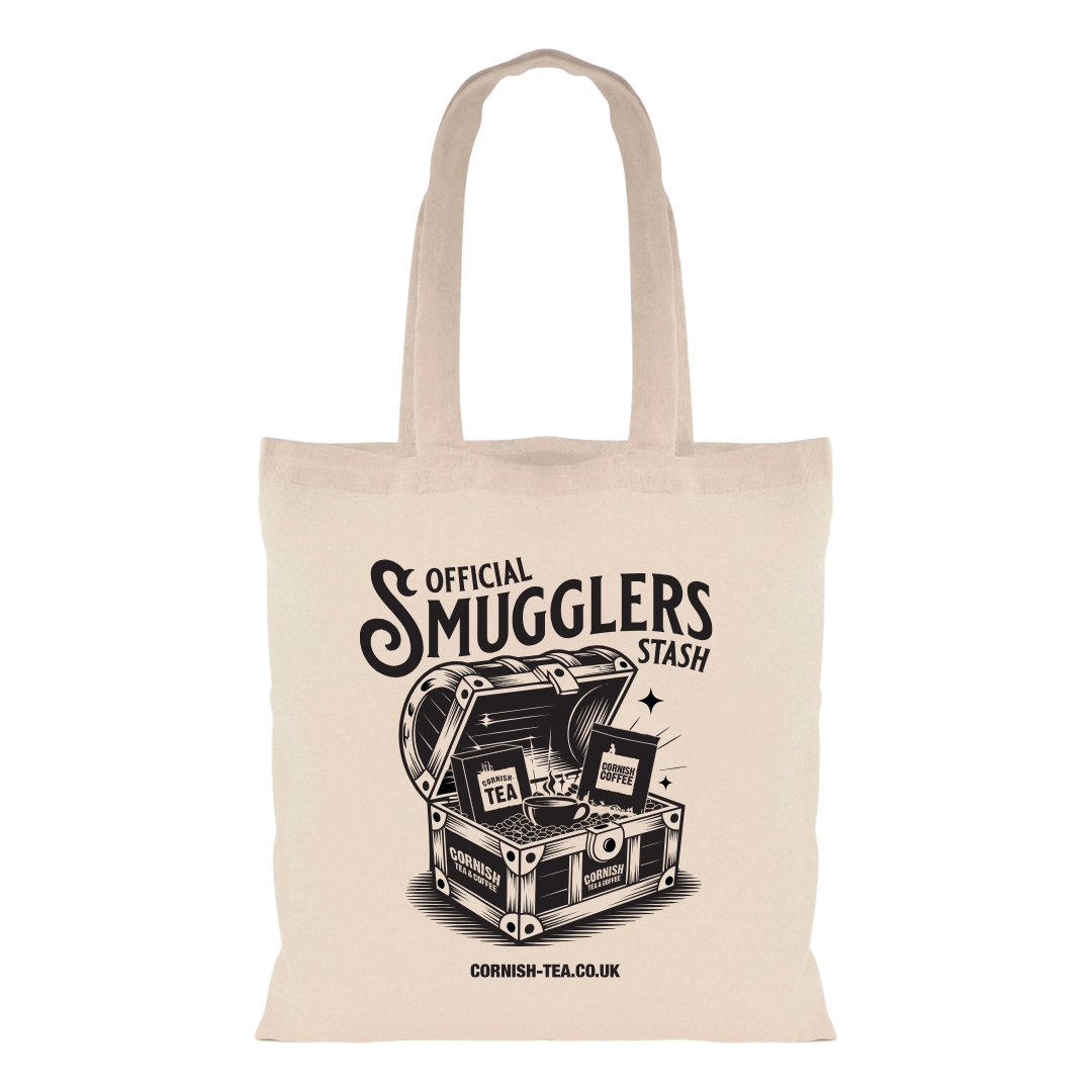 Natural-coloured tote bag with bold black text reading “Official Smugglers Stash” in a stamped-style design, alongside a graphic illustration.